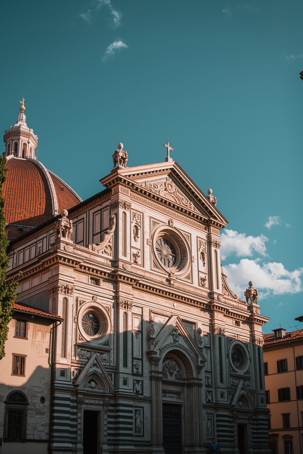 Facade of Basilica di Santa Maria Novella in Florence, Italy, with ornate marble details and blue sky