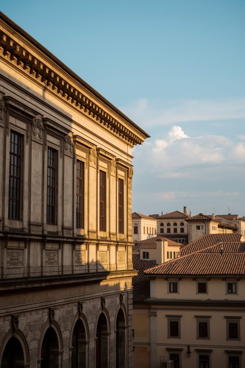 Renaissance palazzo facade with ornate cornice details glowing in golden hour light, with Italian terracotta rooftops in background