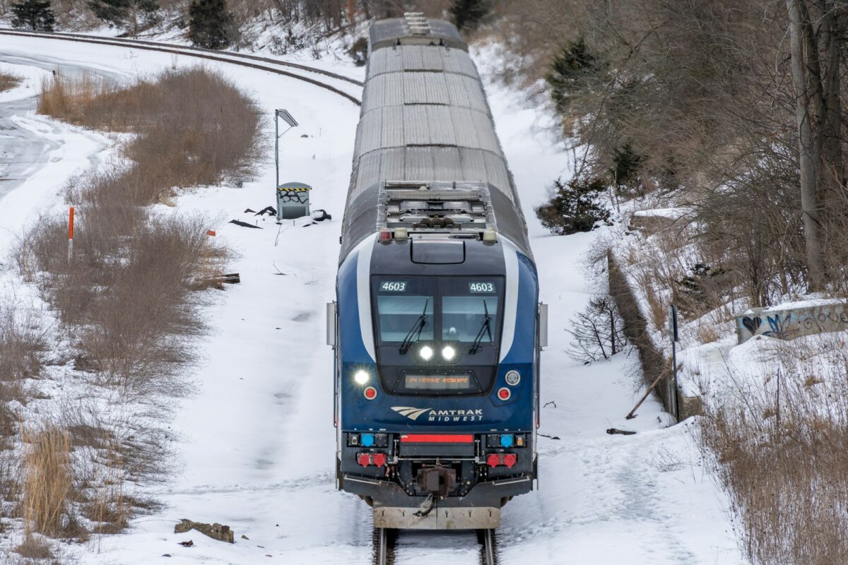 An Amtrak Midwest passenger train rounding a snowy curve near Ann Arbor, Michigan