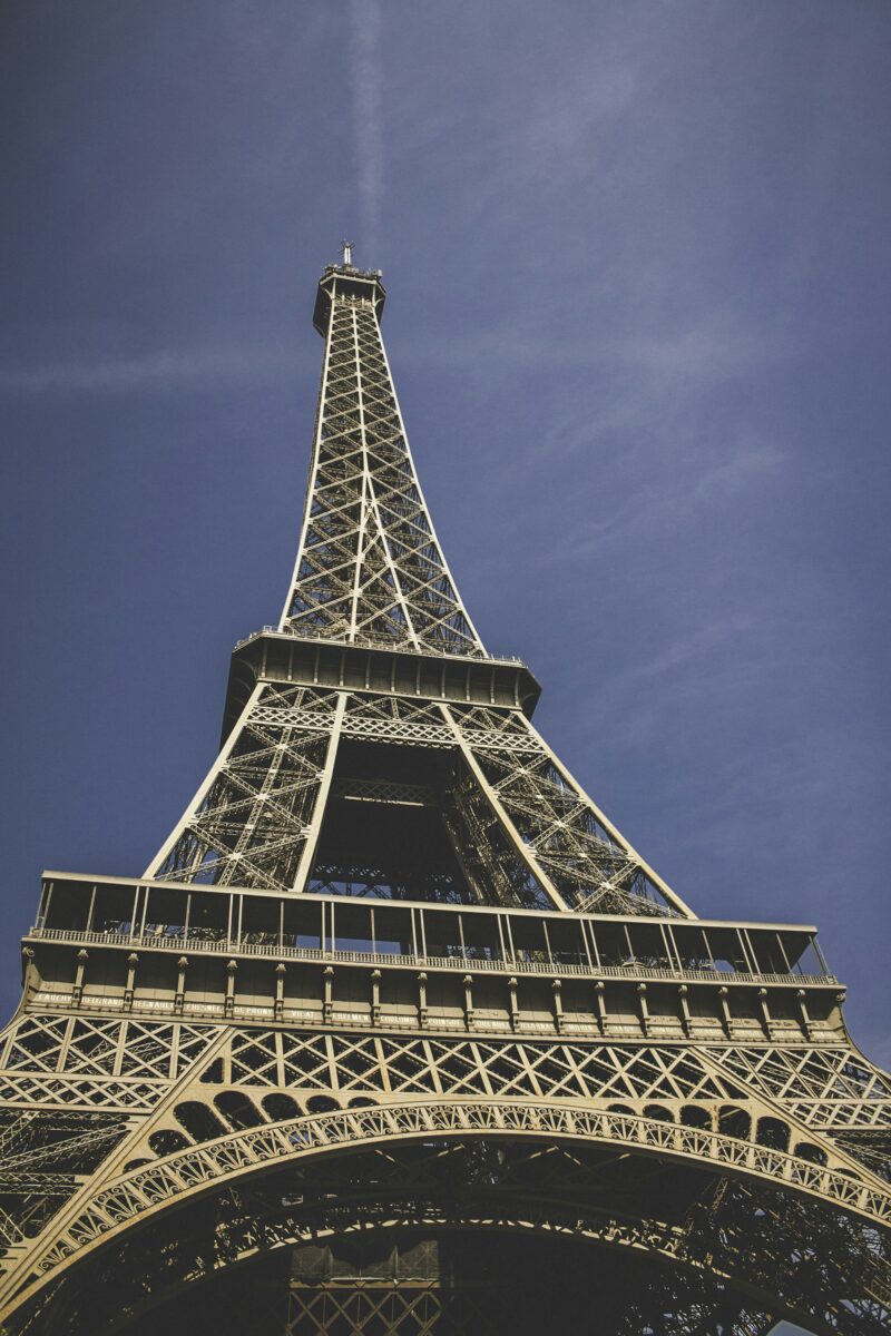 Looking up the Eiffel Tower's iron legs to the first floor platform and the second floor above