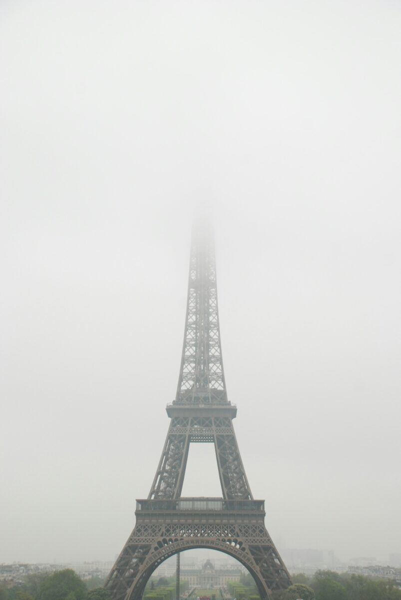 The Eiffel Tower's top hidden in fog above the Champ de Mars