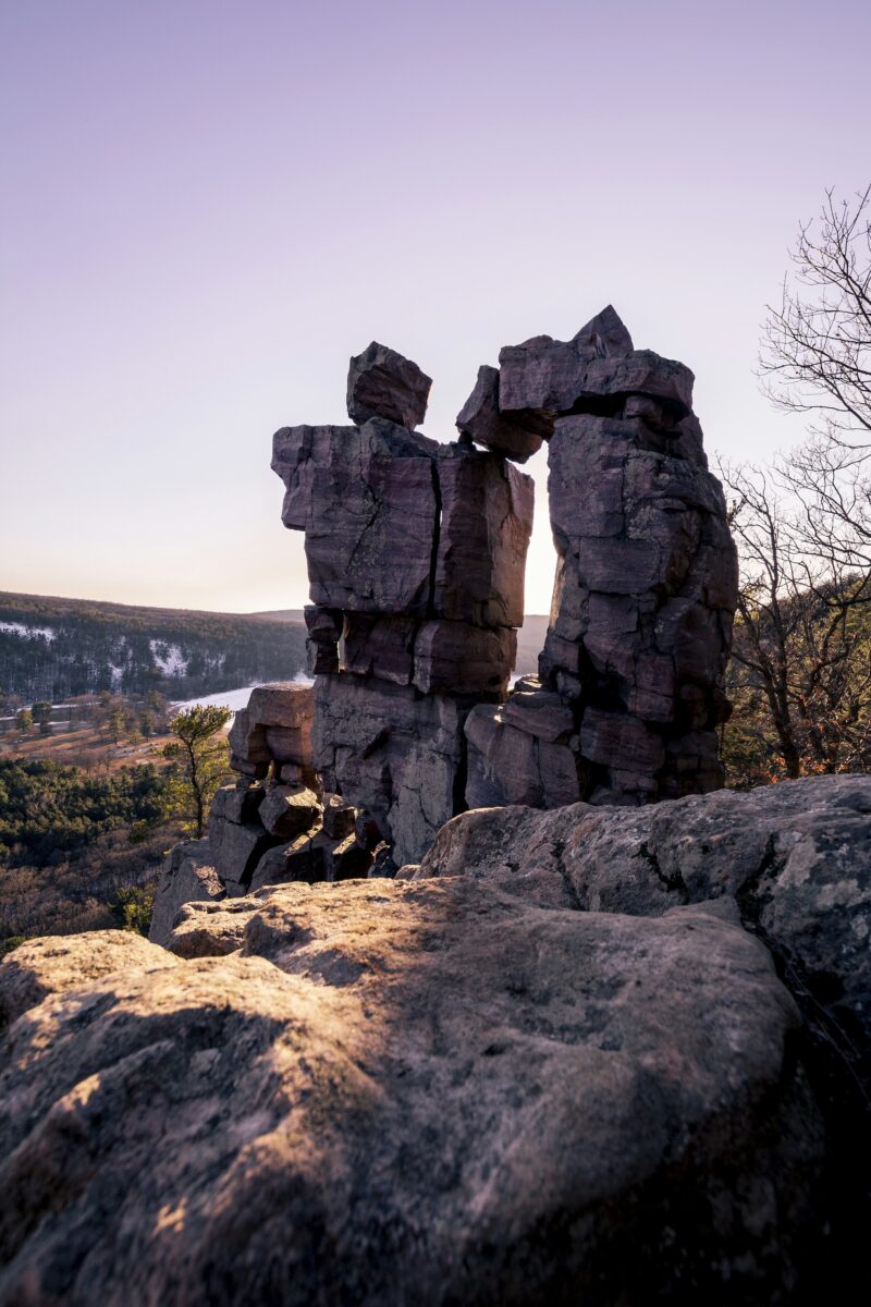 Devil's Doorway, a stacked quartzite rock arch on the bluff above Devil's Lake, with snow on the far hills